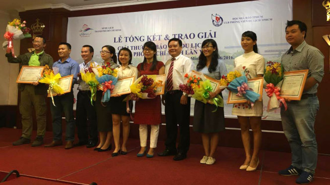Tác giả Yến Trinh (thứ 5 từ trái qua) đại diện nhóm tác giả nhận giải khuyến khích cho tác phẩm “Xích lô “dù” chặt chém du khách” - Ảnh: LÊ NAM