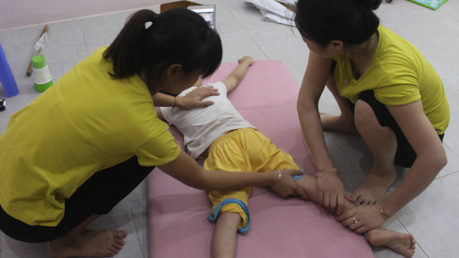 Các cô giáo tại trung tâm Tuệ Quang tập vận động cho trẻ bị tự kỷ  - Ảnh: T.L