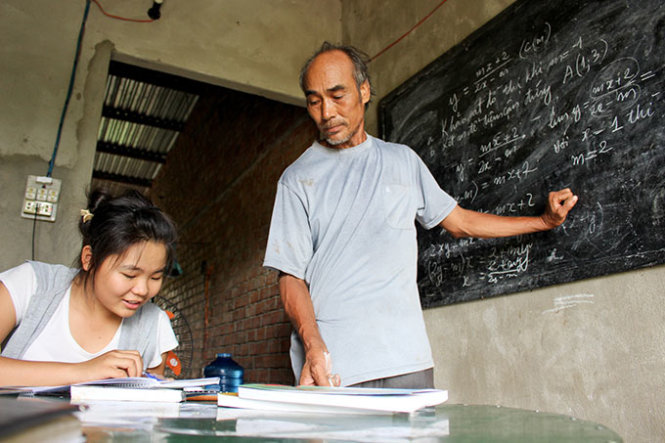 Ông Minh đang “mở lớp” học ôn thi tốt nghiệp THPT cho con gái - Ảnh: Thái Thịnh