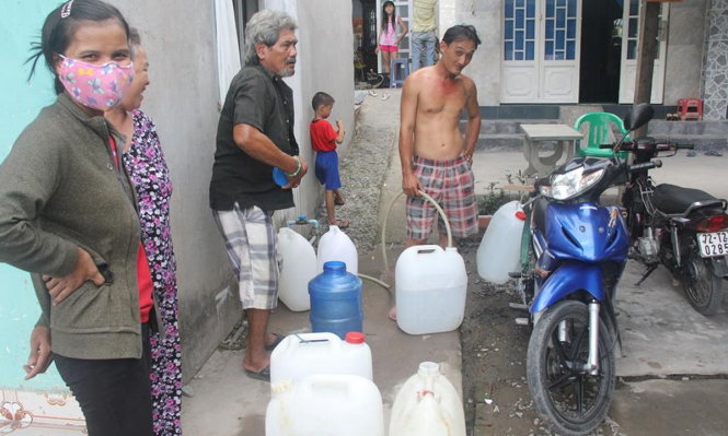 Người dân ở Bình Chánh xin nước giếng về dùng trong một lần bị cúp nước - Ảnh: Q.KHẢI