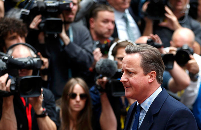 Thủ tướng Anh David Cameron bước qua rừng phóng viên tại Hội nghị thượng đỉnh EU ở Brussels ngày 28-6 - Ảnh: Reuters