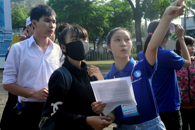 Sinh viên tình nguyện tại hội đồng thi Trường THCS Trần Hưng Đạo (TP.Biên Hòa, Đồng Nai) hướng dẫn thí sinh vào phòng thi - Ảnh: A LỘC