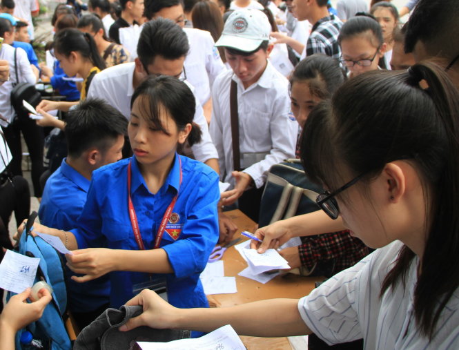 Các sinh viên tình nguyện trường ĐH Ngoại thương giúp thí sinh giữ đồ tại điểm thi trường CĐ Công nghiệp và xây dựng Quảng Ninh chiều 1-7 - Ảnh: ĐỨC HIẾU