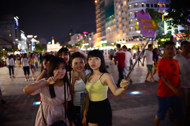 Các bạn trẻ thích thú chụp ảnh trên phố đi bộ Nguyễn Huệ - Ảnh: T.T.D.