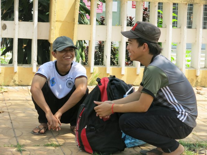 Hai thí sinh ở huyện Vĩnh Thạnh (Cần Thơ) đến trường chờ bạn thi xong sẽ cùng đi xe buýt về quê - Ảnh: T.Trang