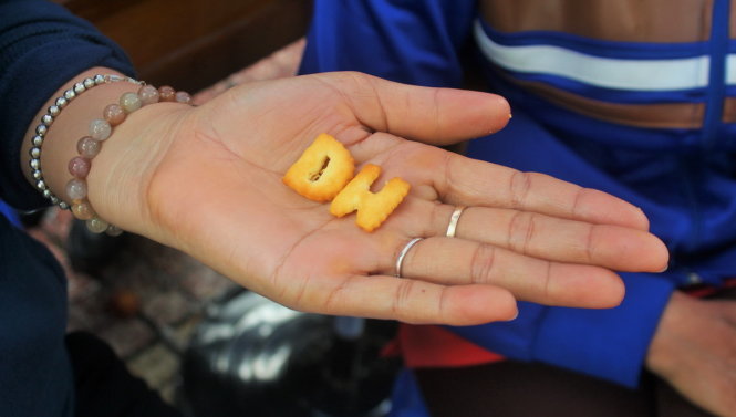 Hai chiếc bánh quy hình chữ “D”, chữ “H” mà các sinh viên tình nguyện tặng phụ huynh ngồi chờ con trước điểm thi Trường THPT chuyên Lê Hồng Phong, TP.HCM với lời chúc mong các thí sinh có thể đậu đại học như ý nguyện - Ảnh: NGỌC TUYỀN