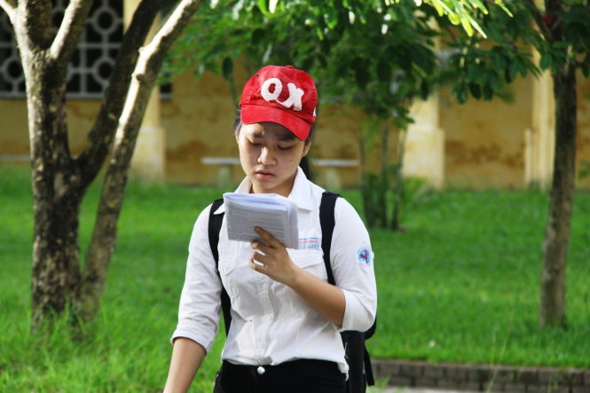 Một thí sinh tại điểm thi ĐH Ngoại ngữ Huế vừa đi vừa ôn bài - Ảnh: VĂN DINH