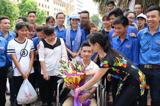 Tình nguyện viên tại trường ĐH Sư phạm Thái Nguyên chia tay thí sinh Vũ Đại Long sau môn thi - Ảnh: QUANG THẾ