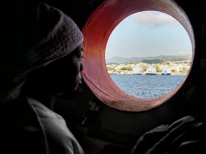Một phụ nữ người tị nạn nhìn qua lỗ cửa của chiếc tàu cứu hộ sau khi được lực lượng hải quân Italy cứu ngày 25-6-206 - Ảnh: AP