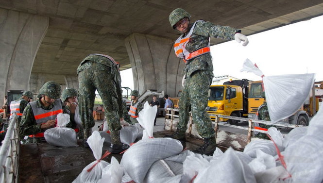 Binh sĩ Đài Loan phân phát bao cát cho người dân huyện Ilan để họ chuẩn bị phòng chống bão - Ảnh: EPA