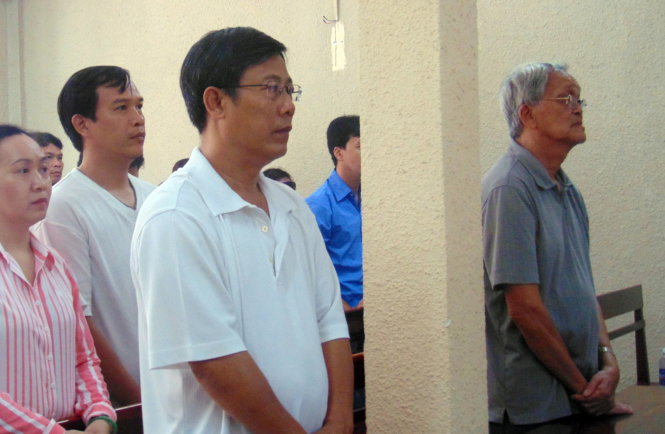 Ông Lưu Tiến Bình (đứng bên trái, hàng đầu) và ông Nguyễn Bùi (đứng bên phải, hàng đầu) bên phải nghe tòa tuyên án, sáng 08-7. Ảnh: Đông Hà.
