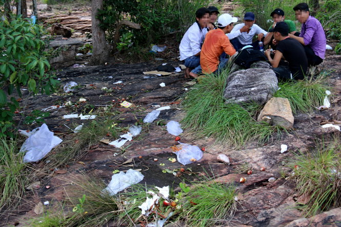 Nhóm bạn trẻ ngồi ăn nhậu ngay bên những bãi rác ở suối Trúc - Ảnh: NGỌC HIỂN