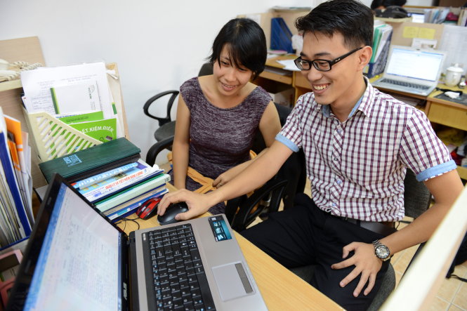 Nguyễn Văn Phú trao đổi công việc với đồng nghiệp - Ảnh: DUYÊN PHAN