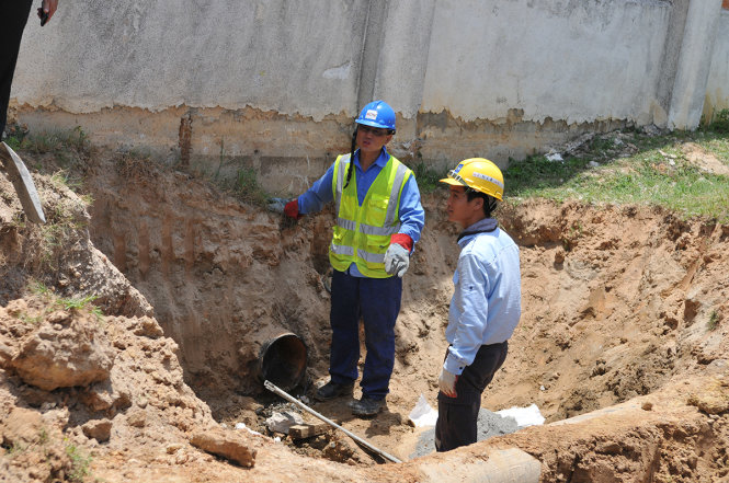 Các công nhân Formosa thực hiện việc cắt bỏ đường ống và bịt kín phần cắt - Ảnh: HỒ VĂN