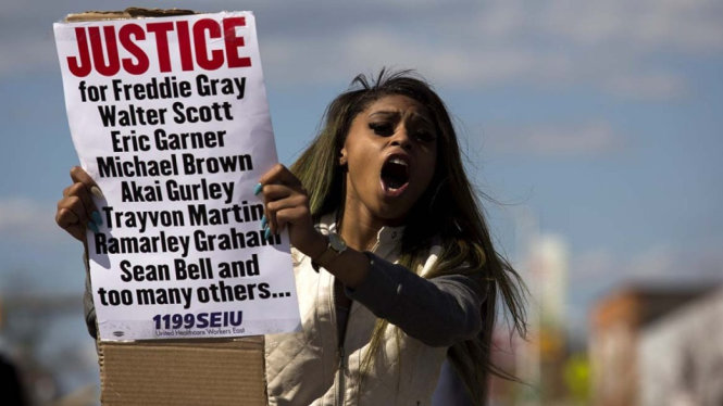 Một phụ nữ da màu biểu tình phản đối phân biệt đối xử của công lý. Trên tấm biển cầm theo có tên những người da màu đã thiệt mạng - Ảnh: AFP