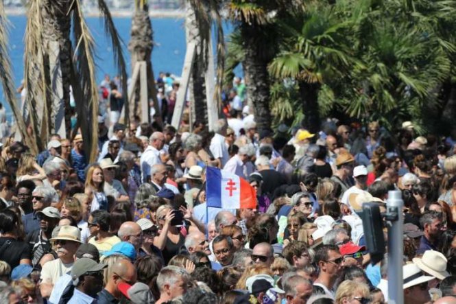 Người dân tập trung dành một phút mặc niệm tưởng nhớ các nạn nhân trong vụ tấn công tại Promenade des Anglais ở Nice - Ảnh: AFP