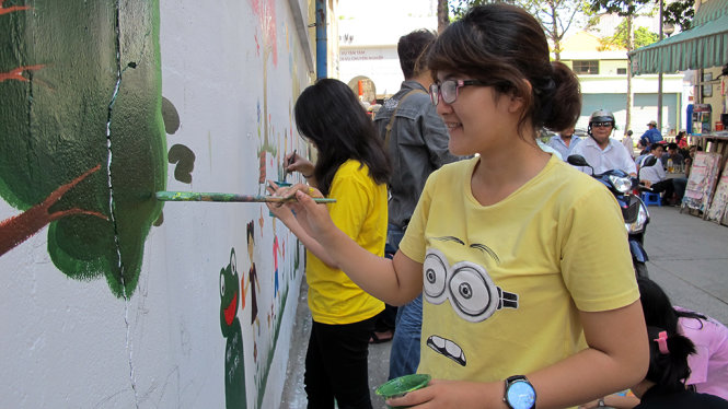 Các bạn sinh viên Trường đại học Văn Lang (TP.HCM) đang vẽ tranh làm đẹp tuyến hẻm 391 đường Trần Hưng Đạo, Q.1, TP.HCM - Ảnh: K.ANH