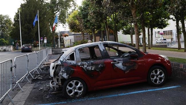 Một chiếc xe bị cháy trong cuộc đụng độ giữa cảnh sát và người biểu tình bên ngoài hội trường thành phố tại Beaumont-sur-Oise, bắc ngoại ô Paris - Ảnh: AFP