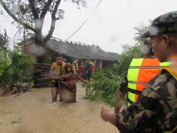 Lính Nepal giúp sơ tán những người mắc kẹt trong vùng nước lũ - Ảnh: Reuters