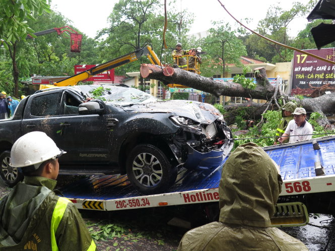 Một ôtô được lực lượng cứu hộ đưa đi sau khi bị cây ngã đè trong bão tại Hà Nội - Ảnh: Q.THẾ