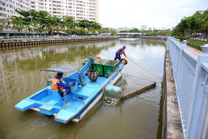 Nhân viên Công ty TNHH MTV Môi Trường Đô Thị TP.HCM vớt cá chết trên kênh Nhiêu Lộc – Thị Nghè vào trưa 2-8 - Ảnh: HỮU KHOA