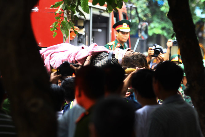 Một nạn nhân được cứu hộ đưa ra khỏi nhà sập lên xe cấp cứu - Ảnh: Nguyễn Khánh