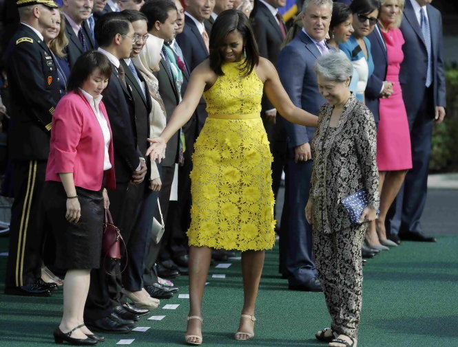 Bà Hà Tinh với trang phục giản dị và chiếc ví nhân văn bên cạnh bà Michelle Obama ngày 2-8 tại Nhà Trắng - Ảnh: Reuters