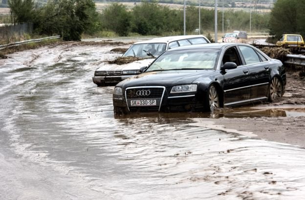 Hàng loạt ô tô bị kẹt trong bùn, nước - Ảnh: EPA