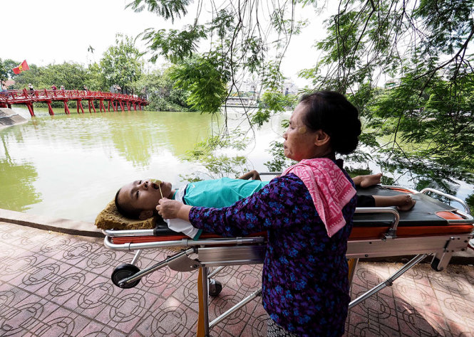 Phạm Sĩ Long đang được mẹ là bà Trần Thị Hà đưa ra Hồ Gươm chơi, ảnh chụp sáng 10-8