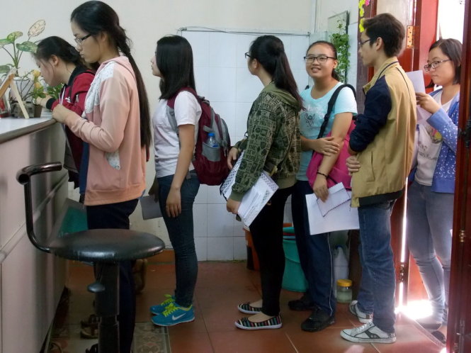 Thí sinh đang xếp hàng đợi nộp bảng điểm gốc để xác nhận nhập học tại Trường ĐH Khoa học xã hội và nhân văn TP.HCM sáng 15-8 - Ảnh: ĐÀM NA