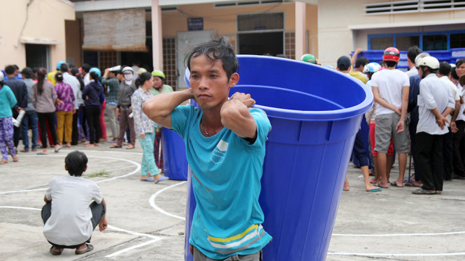Người dân vùng nhiễm mặn xã Long Định, huyện Bìn Đại, tỉnh Bến Tre nhận thùng chứa nước để trữ nước mưa - Ảnh: Mậu Trường