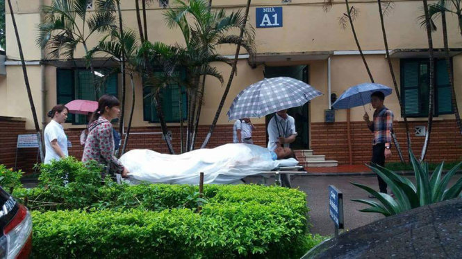 Ảnh chuyển bệnh nhân trong mưa sáng 22-8 tại Bệnh viện Việt Đức
- Ảnh: THÚY ANH