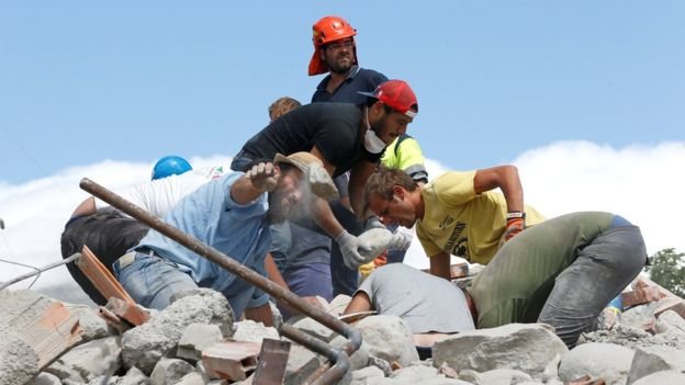 Các nhân viên cứu hộ dùng tay không đào bới đống đổ nát - Ảnh: Reuters