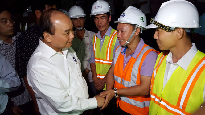 Thủ tướng Nguyễn Xuân Phúc bắt tay chúc mừng, động viên các công nhân làm hầm đèo Cả - Ảnh: DUY THANH