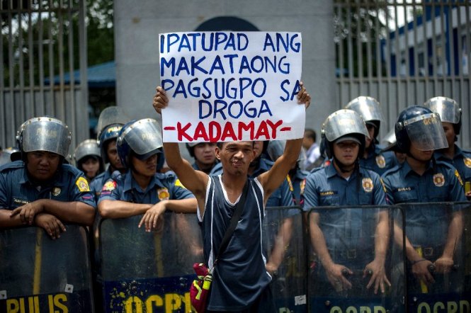Một nhà hoạt động giơ cao tấm biển lên án các vụ giết người không qua xét xử liên quan tới chiến dịch chống tội phạm ma túy của ông Rodrigo Duterte tại Manila ngày 24-8 - Ảnh: AFP