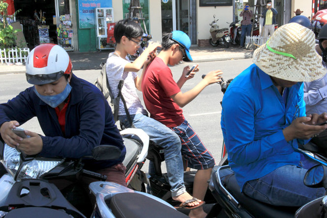 Một nhóm bạn trẻ đậu xe dưới lòng đường để bắt Pokemon ngay trước chợ Hàn, TP Đà Nẵng - Ảnh: T.TRUNG