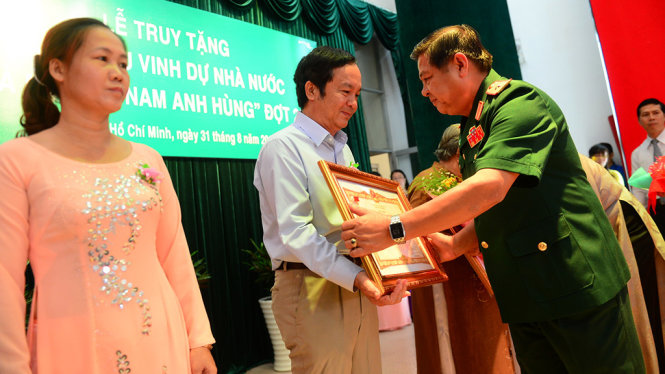 Thiếu tướng Phan Tấn Tài – phó Tư lệnh Quân khu 7 trao tặng danh hiệu Bà Mẹ VN Anh hùng cho đại diện gia đình các bà mẹ trong lễ truy tặng đợt 28 sáng 31-8 - Ảnh: QUANG ĐỊNH