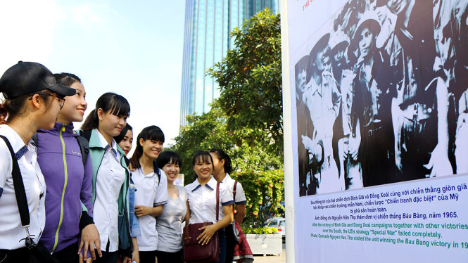 Các bạn trẻ thưởng lãm các hình ảnh tại Phố đi bộ Nguyễn Huệ trong buổi sáng khai mạc - Ảnh: NGỌC DƯƠNG