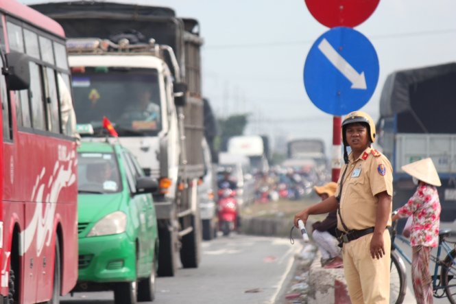 Lực lượng cảnh sát giao thông vất vả điều tiết giao thông trên quốc lộ 1, đoạn qua huyện Châu Thành, tỉnh Tiền Giang nhưng ùn ứ vẫn xảy ra do lượng xe quá nhiều - Ảnh: MẬU TRƯỜNG