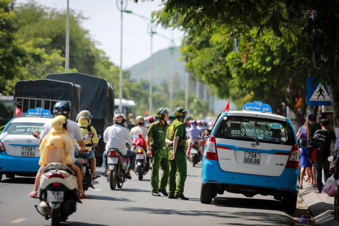 Cảnh sát 113 nhắc nhở tài xế đậu xe trên đường Trần Phú. Theo quy định mới, từ 1-9, đường Trần Phú là một trong năm tuyến đường sẽ cấm tất cả các loại ô tô dừng đỗ - Ảnh: TIẾN THÀNH