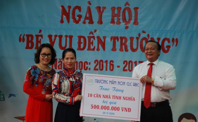 Bà Anh Thư (bìa trái) trao 500 triệu đồng cho chủ tịch quận Hải Châu - Ảnh: V.Hùng