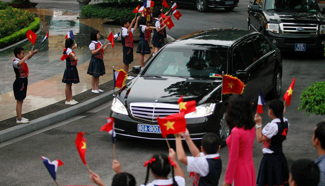 Các trẻ em thủ đô vẫy cờ chào đón đoàn xe của Tổng thống Francois Hollande - Ảnh: REUTERS