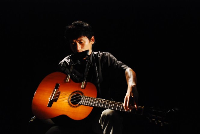 Nghệ sĩ Nguyễn Thế Vinh một tay trình diễn cùng lúc đàn guitar và kèn harmonica - Ảnh nhân vật cung cấp