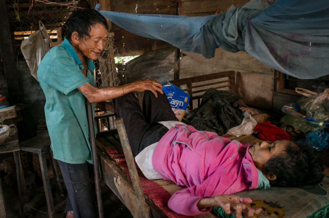 Ông Nguyễn Tư chăm sóc người vợ già yếu, tàn tật trong căn nhà nhỏ ở thôn Phước Thọ 1 - Ảnh: TIẾN THÀNH