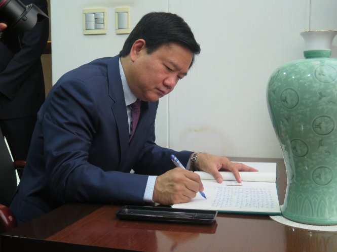 Bí thư Thành ủy TPHCM Đinh La Thăng ghi sổ lưu niệm tại văn phòng Tổng Lãnh sự - Ảnh: HỒNG HIỆP