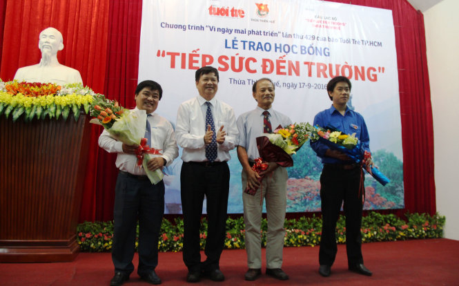 Ông Nguyễn Dung - phó chủ tịch UBND tỉnh Thừa Thiên - Huế trao hoa tri ân cho sự đóng góp của báo Tuổi Trẻ và các nhà hảo tâm - Ảnh: MINH AN
