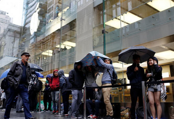 Người mua xếp hàng trong mưa ở cửa hàng Apple Store Sydney Úc ngày đầu mở bán iPhone 7 và đồng hồ Apple Watch 2 - Ảnh: Reuters