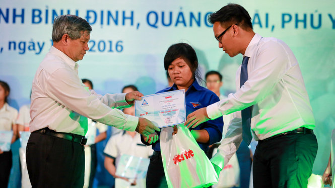 Ông Huỳnh Cao Minh , phó giám đốc Makerting Công ty Ô tô Đô Thành (phải) và ông Hồ Sỹ Dũng, phó chủ tịch Mặt trận Tổ quốc Bình Định trao học bổng cho các tân sinh viên nghèo - Ảnh: TIẾN THÀNH