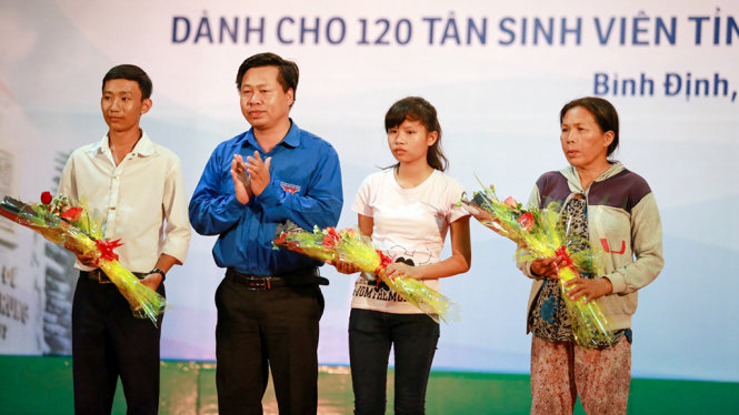 Anh Nguyễn Hoàng Hiệp, phó bí thư Tỉnh đoàn Quảng Ngãi tặng hoa cho phụ huynh và tân sinh viên trong buổi giao lưu - Ảnh: TIẾN THÀNH