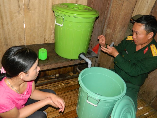 Thượng úy Dũng lắp bình lọc nước cho người dân sử dụng - Ảnh: T. MAI